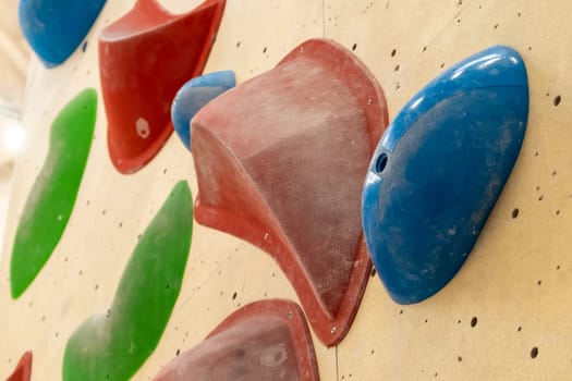 Stone hooks or grips on the artificial climbing wall in bouldering gym.