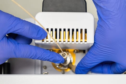 Chemist inzert a nebuliser into ion source of mass spectrometer. Liquid chromatography with mass detector. Maintenance of the instrument
