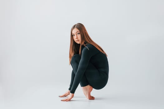 Taking a break. Young woman in sportive clothes doing gymnastics indoors.