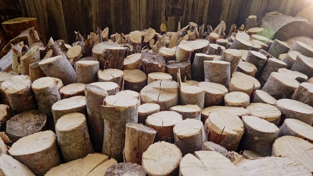 Logs of chopped and stacked firewood stacks. Fuel for heating in fireplaces and furnaces. Woodpile preparation for cold winter. Concept of renewable energy natural resources. High quality