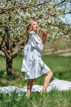 Portrait of a blonde in the park. Beautiful woman with long blond hair in a blue dress