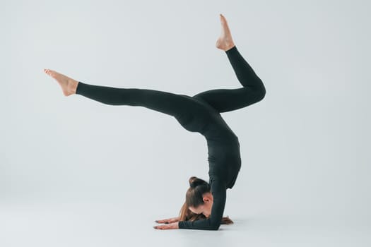 Healthy person. Young woman in sportive clothes doing gymnastics indoors.