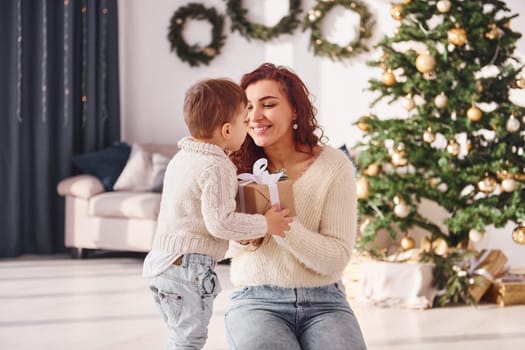 Mother with her little son is at home. Christmas decorations.