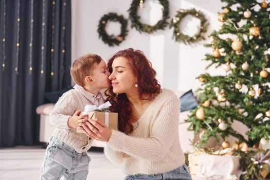 Mother with her little son is at home. Christmas decorations.