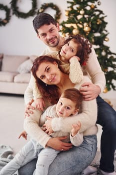 Posing for the camera. Family celebrating new year with their children at home.