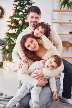 Posing for the camera. Family celebrating new year with their children at home.