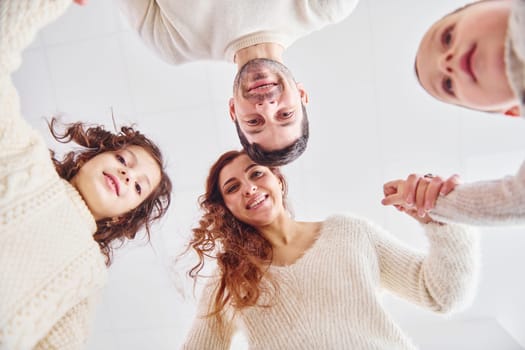 View from below. Happy family looking down and having fun.