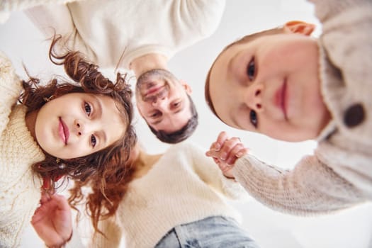 View from below. Happy family looking down and having fun.
