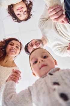 View from below. Happy family looking down and having fun.