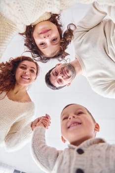 Smiling and having fun. View from below. Happy family looking down.