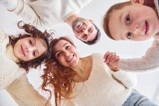 Smiling and having fun. View from below. Happy family looking down.
