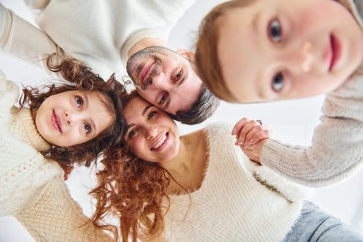 Smiling and having fun. View from below. Happy family looking down.