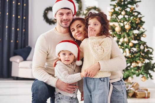 In christmas hats. Family celebrating new year with their children at home.