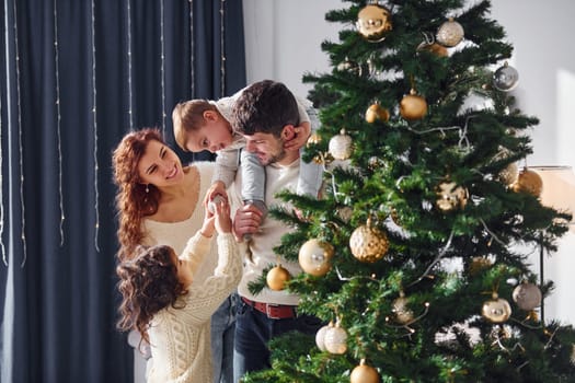 Conception of holidays. Family celebrating new year with their children at home.