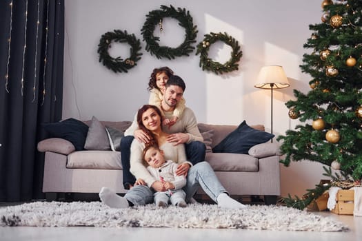 Conception of holidays. Family celebrating new year with their children at home.
