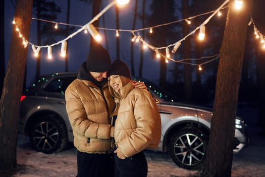 Embracing each other. Couple standing in the forest and celebrating New year.