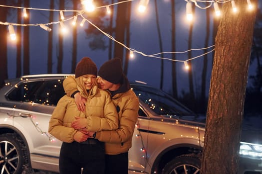 Embracing each other. Couple standing in the forest and celebrating New year.