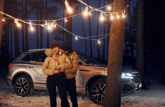 Embracing each other. Couple standing in the forest and celebrating New year.