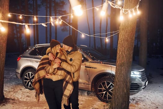 Conception of love. Couple standing in the forest and celebrating New year.
