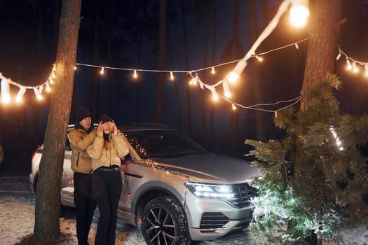 Conception of love. Couple standing in the forest and celebrating New year.