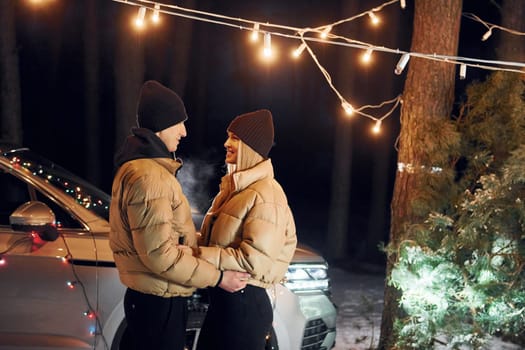 Conception of love. Couple standing in the forest and celebrating New year.