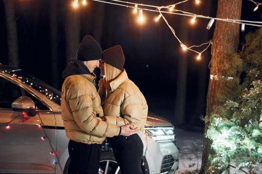 Looking at each other. Couple standing in the forest and celebrating New year.