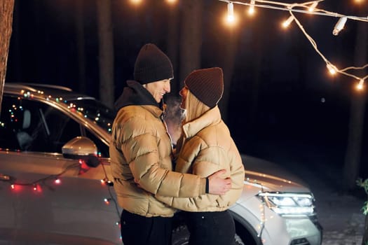 Looking at each other. Couple standing in the forest and celebrating New year.