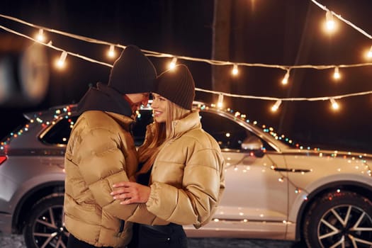 Holiday mood and decorations. Couple standing in the forest and celebrating New year.