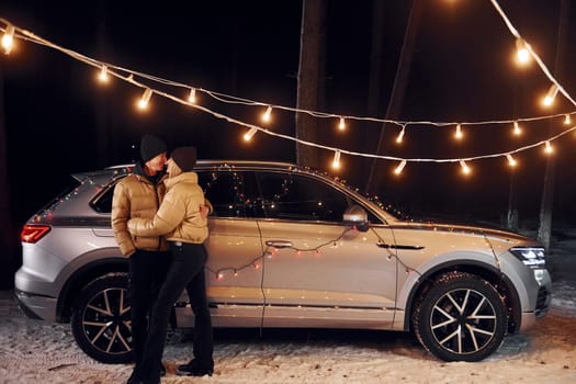 Love and hugs. Couple standing in the forest and celebrating New year.