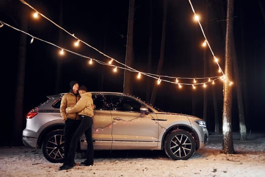 Love and hugs. Couple standing in the forest and celebrating New year.