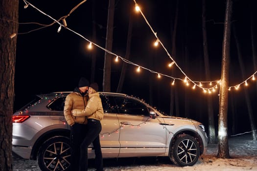 Love and hugs. Couple standing in the forest and celebrating New year.