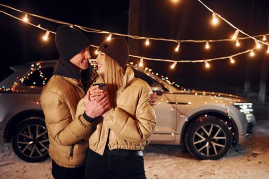 Love and hugs. Couple standing in the forest and celebrating New year.