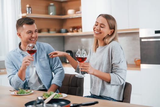 Tasting delicious food. Couple at home on the modern kitchen.