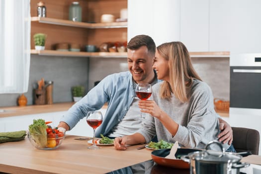 Tasting delicious food. Couple at home on the modern kitchen.