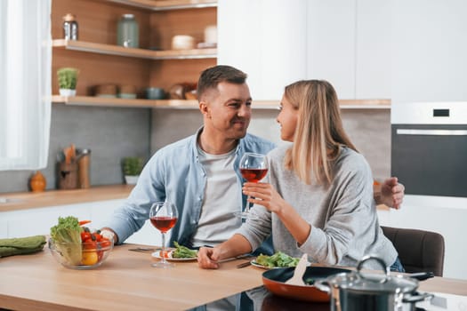 Tasting delicious food. Couple at home on the modern kitchen.