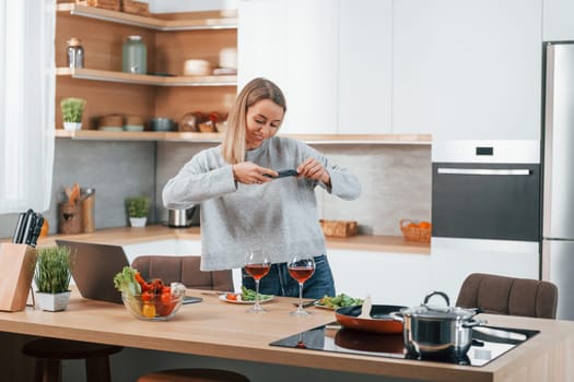 Taking pictures. Woman preparing food at home on the modern kitchen.