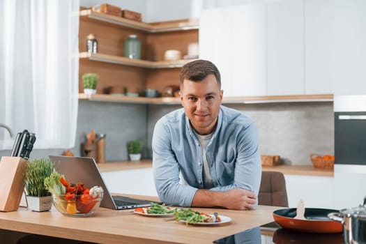 Man preparing food at home on the modern kitchen.