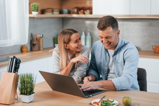 Having fun. Couple preparing food at home on the modern kitchen.