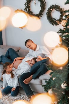 Laying down on the bed. Happy family celebrating holidays indoors together.