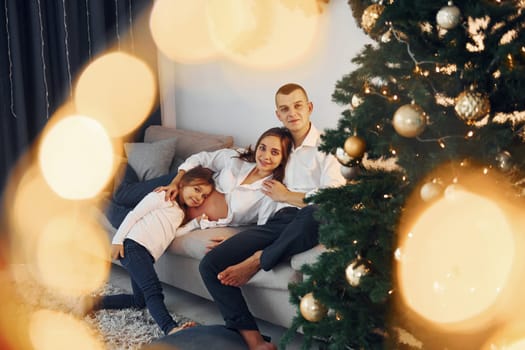 With Christmas tree. Happy family celebrating holidays indoors together.