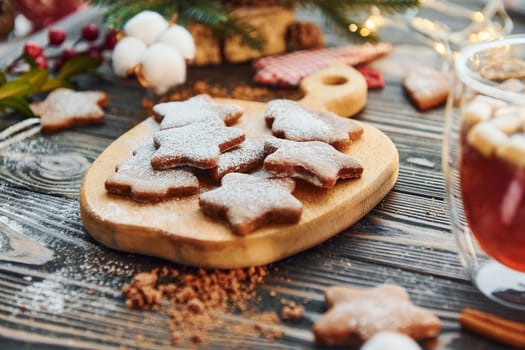 Cookies is on the apple shaped wooden object. Christmas background with holiday decoration.