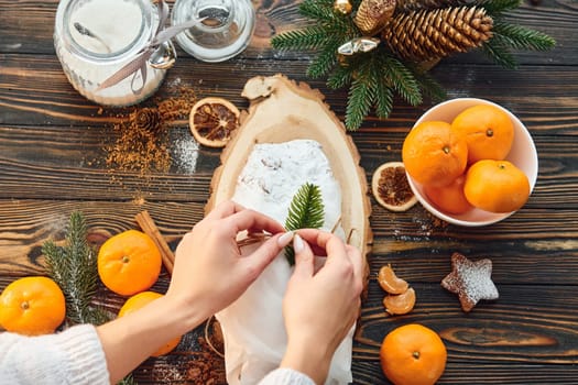 Woman working with stollen. Christmas background with holiday decoration.