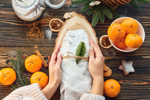Woman working with stollen. Christmas background with holiday decoration.