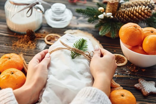 Woman working with stollen. Christmas background with holiday decoration.