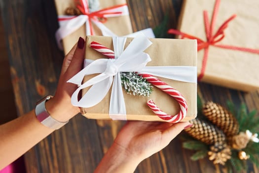 Woman holding gift box. Christmas background with holiday decoration.