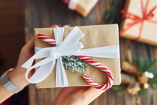 Woman holding gift box. Christmas background with holiday decoration.