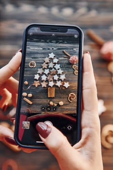 Woman holding phone. Christmas background with holiday decoration.