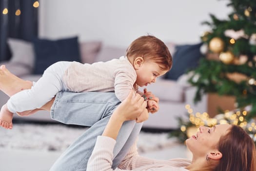 Having fun. Mother with her little daughter is indoors at home together.