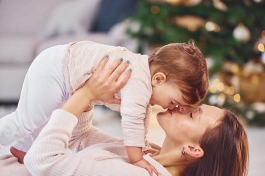 Having fun. Mother with her little daughter is indoors at home together.