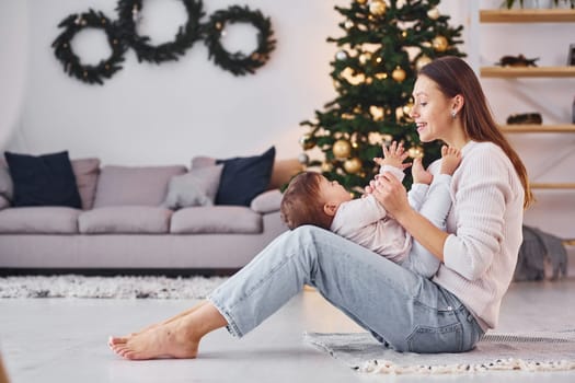 Playing with each other. Mother with her little daughter is indoors at home together.